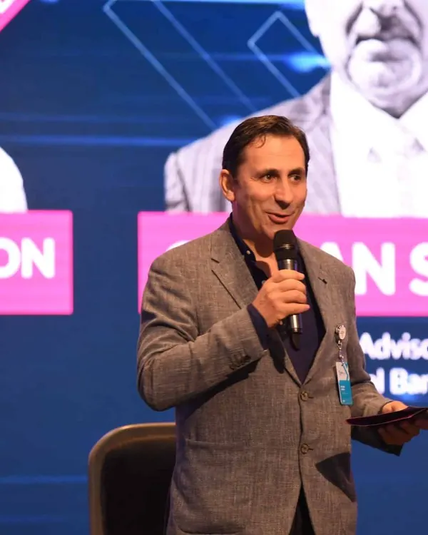 Dinis Guarda speaking on stage with a microphone